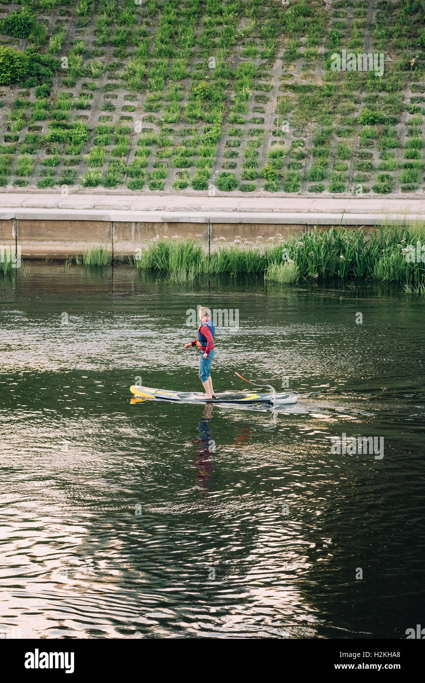 Vilnius, Litauen - 8. Juli 2016: Junger Mann Praxis Stand Up Paddeln SUP oder Standup Paddle-Boarding am Fluss Neris Stockfoto