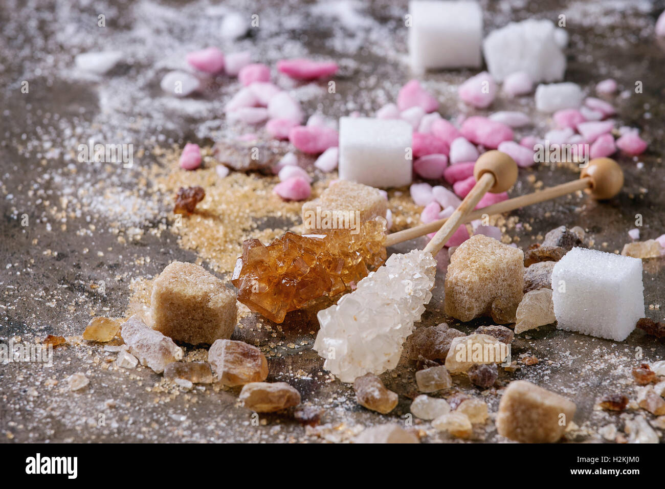 Vielzahl von Zucker weiß, braun, rosa Früchte granuliert, Würfel und Kristall über alte Textur Eisen Hintergrund. Nahaufnahme Stockfoto