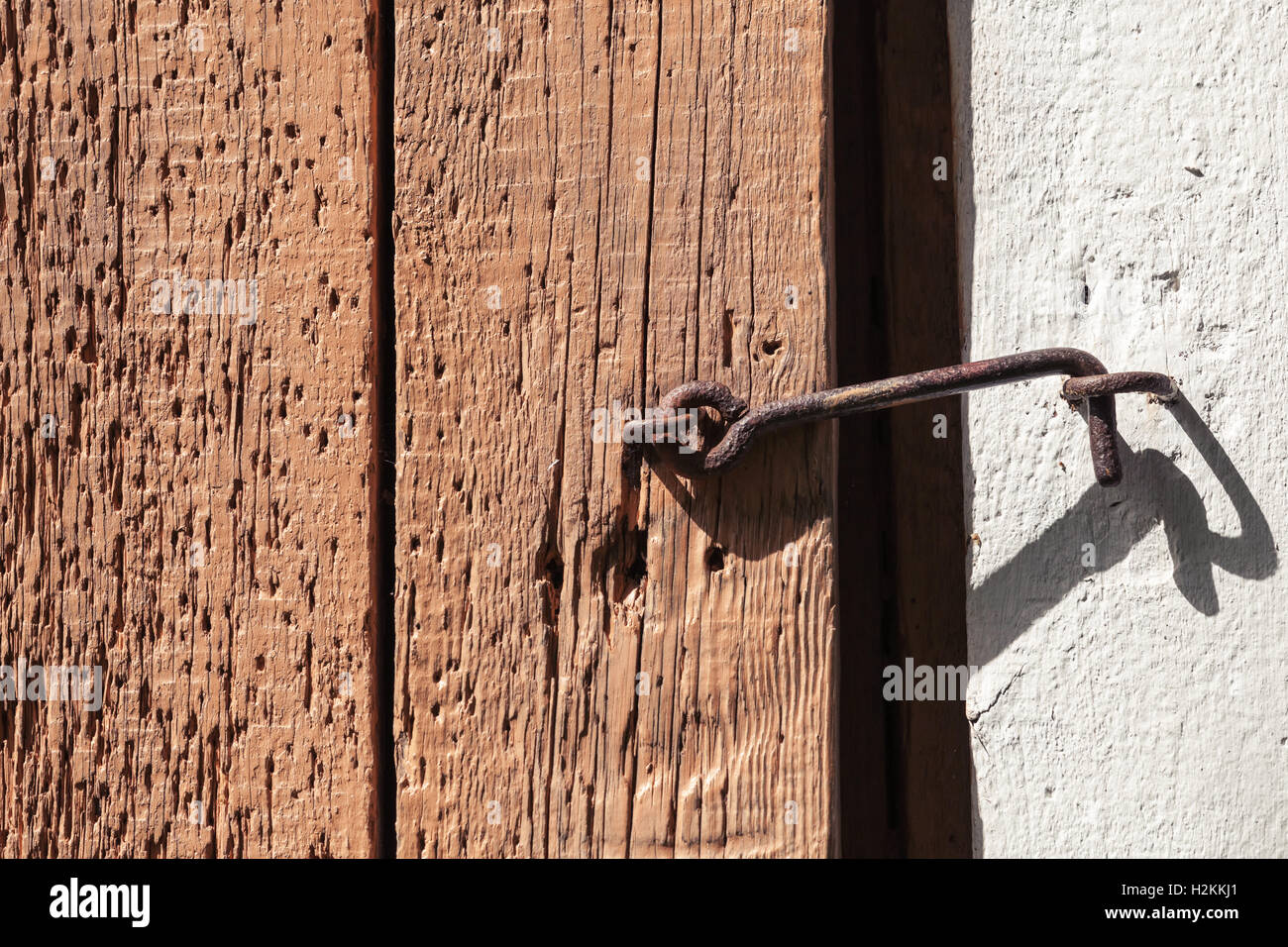Alte verrostete Klinke Haken auf grobe Holztür Stockfoto