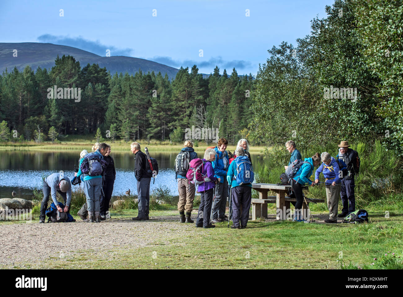 Ältere Wanderer treffen und Vorbereitung zum Wandern entlang Loch Morlich in den Cairngorm Mountains, Schottisches Hochland, Schottland Stockfoto