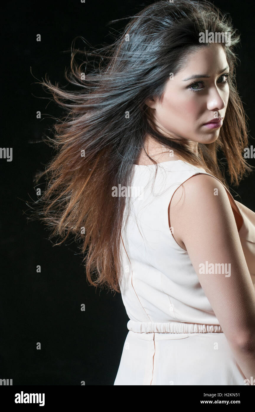 Schöne junge asiatische Frau, die mit Blick auf die Schulter Haare fließt Stockfoto