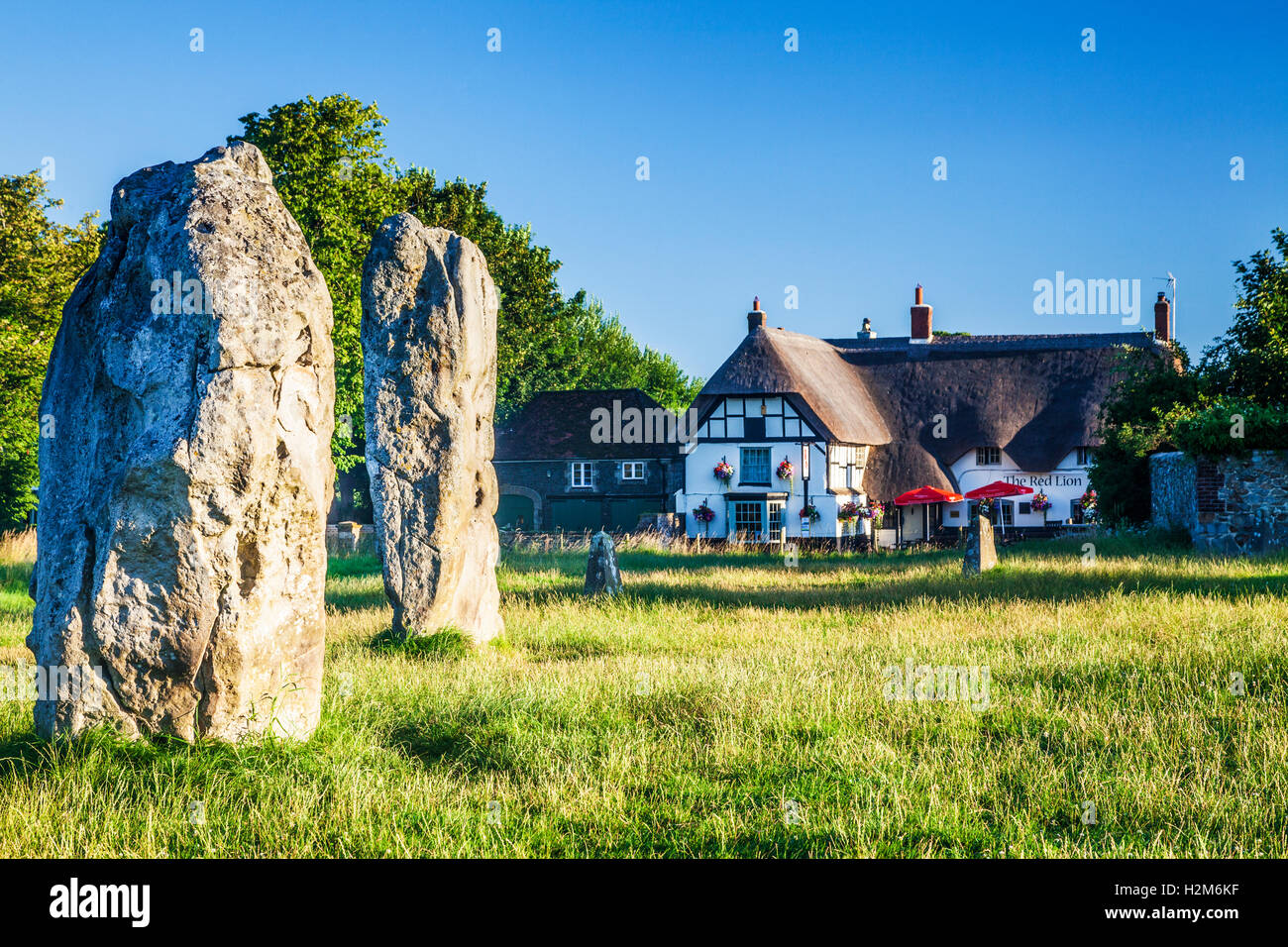 Sarsen Steinen und das Red Lion Pub in Avebury, Wiltshire. Stockfoto