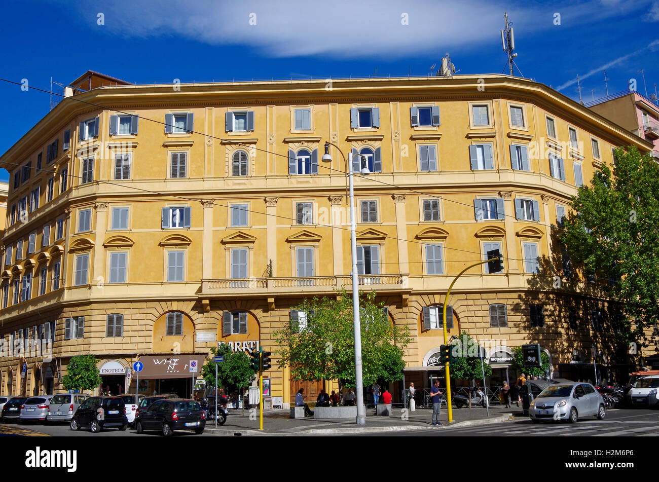 6-stöckiges Gebäude mit Geschäften im Erdgeschoss, in der Piazza Regina Margherita, Rom, in zwei Schattierungen von Gelb lackiert, Stockfoto