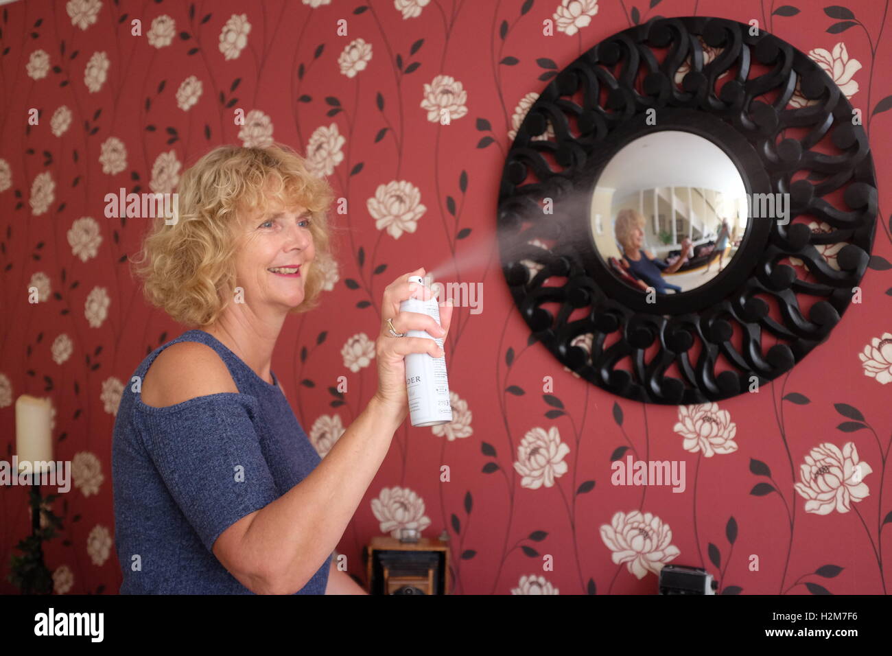 Frau Hausarbeit Reinigung mit Air Freshener Aerosol kann zu Hause Stockfoto