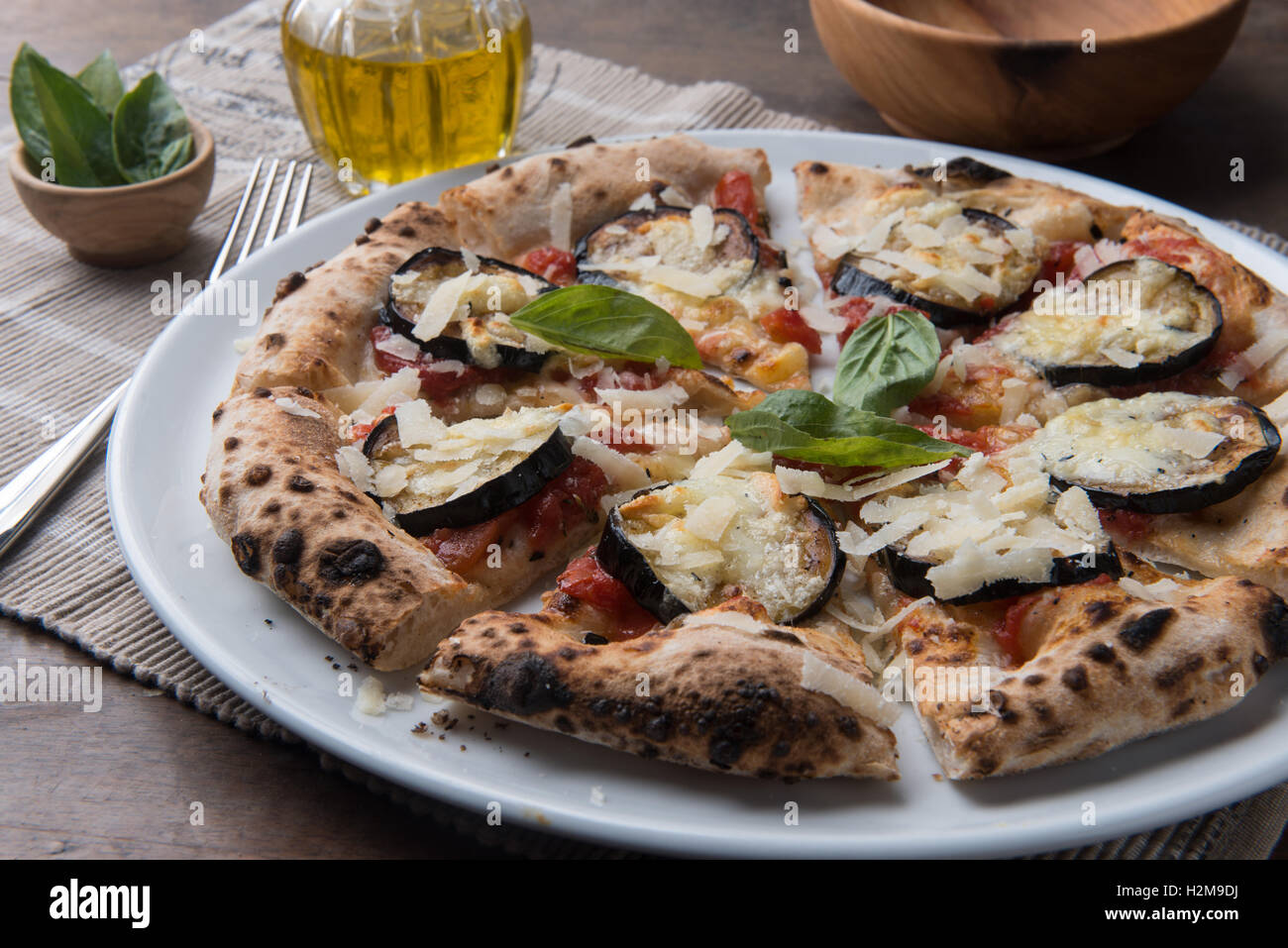 In Scheiben geschnitten parmigiana Pizza Gourmet mit gebratenen Auberginen und Parmesan auf Stilleben Komposition Stockfoto