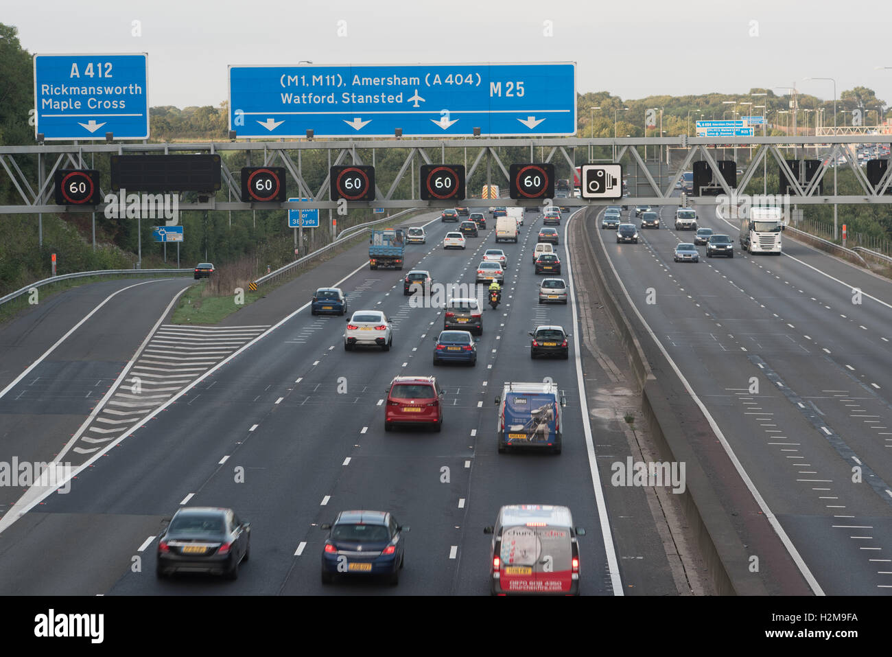 Verkehr M25 nach Süden Westen angrenzend an J17 mit intelligenten Autobahn Geschwindigkeit Beschränkung gantry Stockfoto