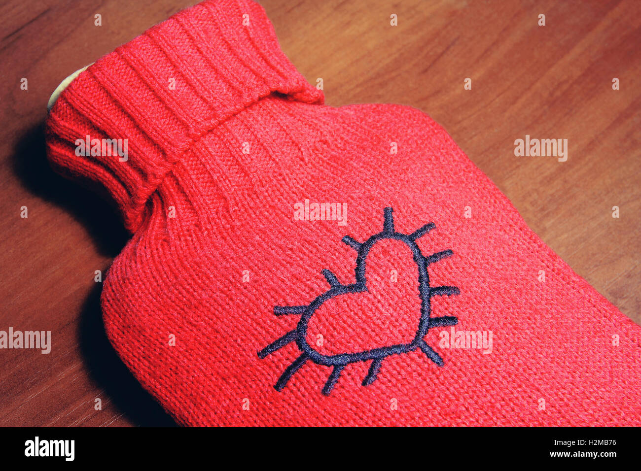 Roten stilvolle wärmer mit Herzen drauf auf hölzernen Hintergrund Stockfoto