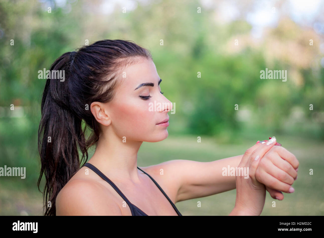 Junge Fitness Mädchen prüft Stoppuhr Tracker an ihrem Handgelenk beim laufen im freien Stockfoto