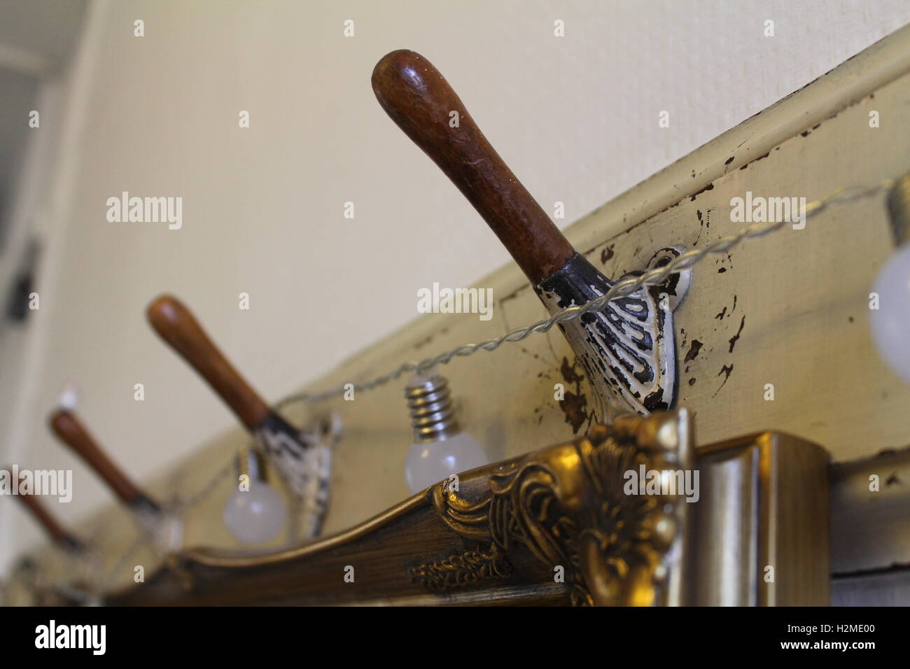 Shabby chic Kleiderhaken mit runden Lichtern über gold, antike Spiegel Stockfoto