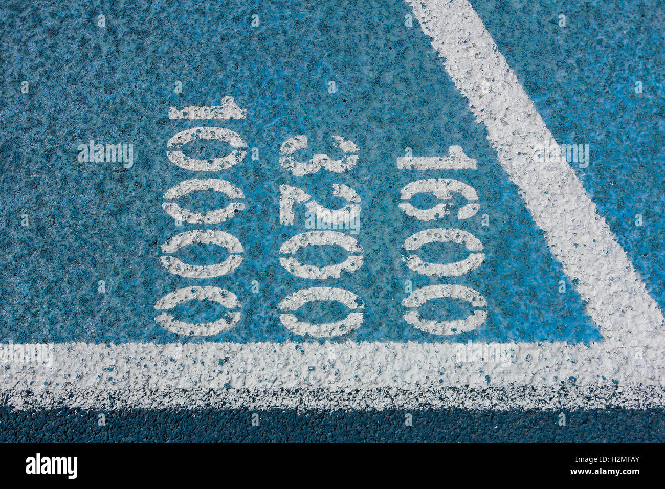 Messung Zahlen auf einem blauen Allwetter-Laufbahn.   1600, 3200, 10000 m. Stockfoto