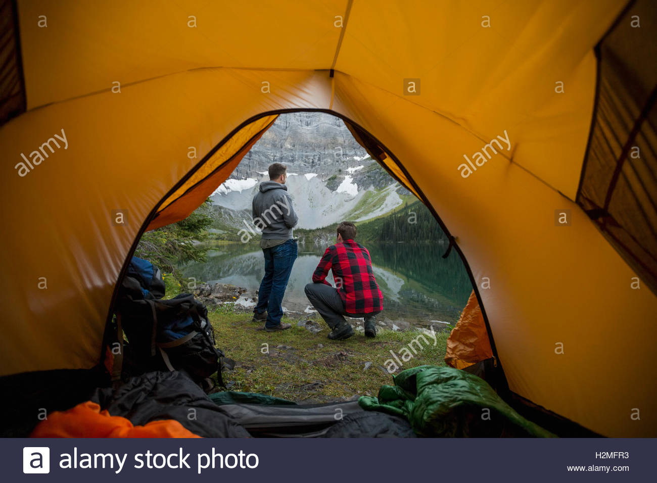 Männer suchen bei Blick auf den See außerhalb camping Zelt Stockfoto