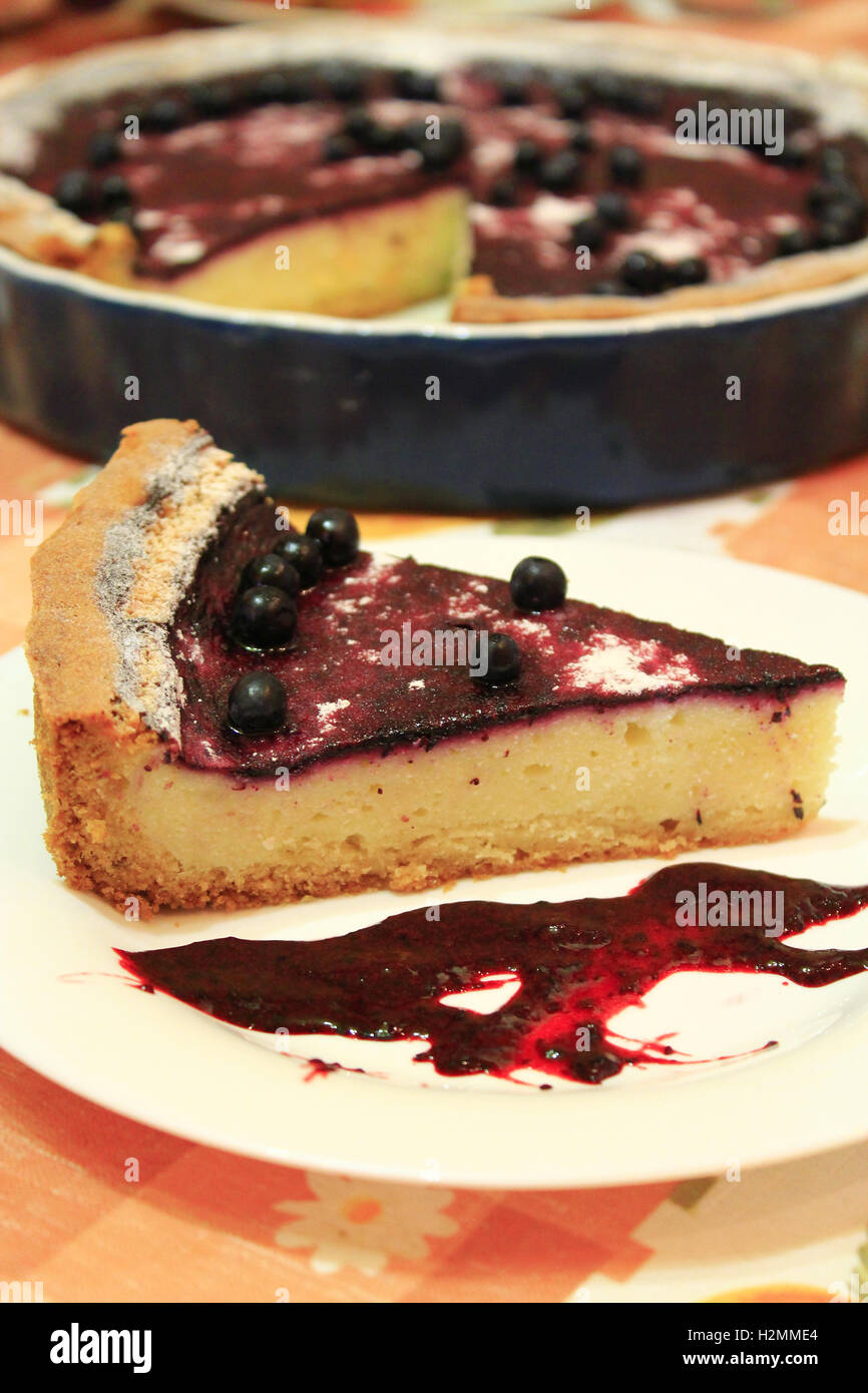 frische Kuchen mit Heidelbeeren auf dem Teller und Tasse Tee Stockfoto