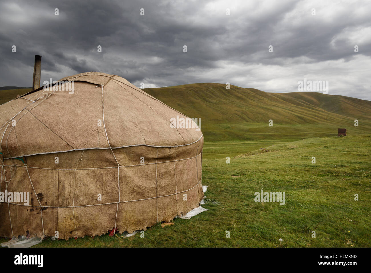 Jurte mit Kamin und Nebengebäude in kargen Weiden von Assy Plateau Kasachstan Stockfoto