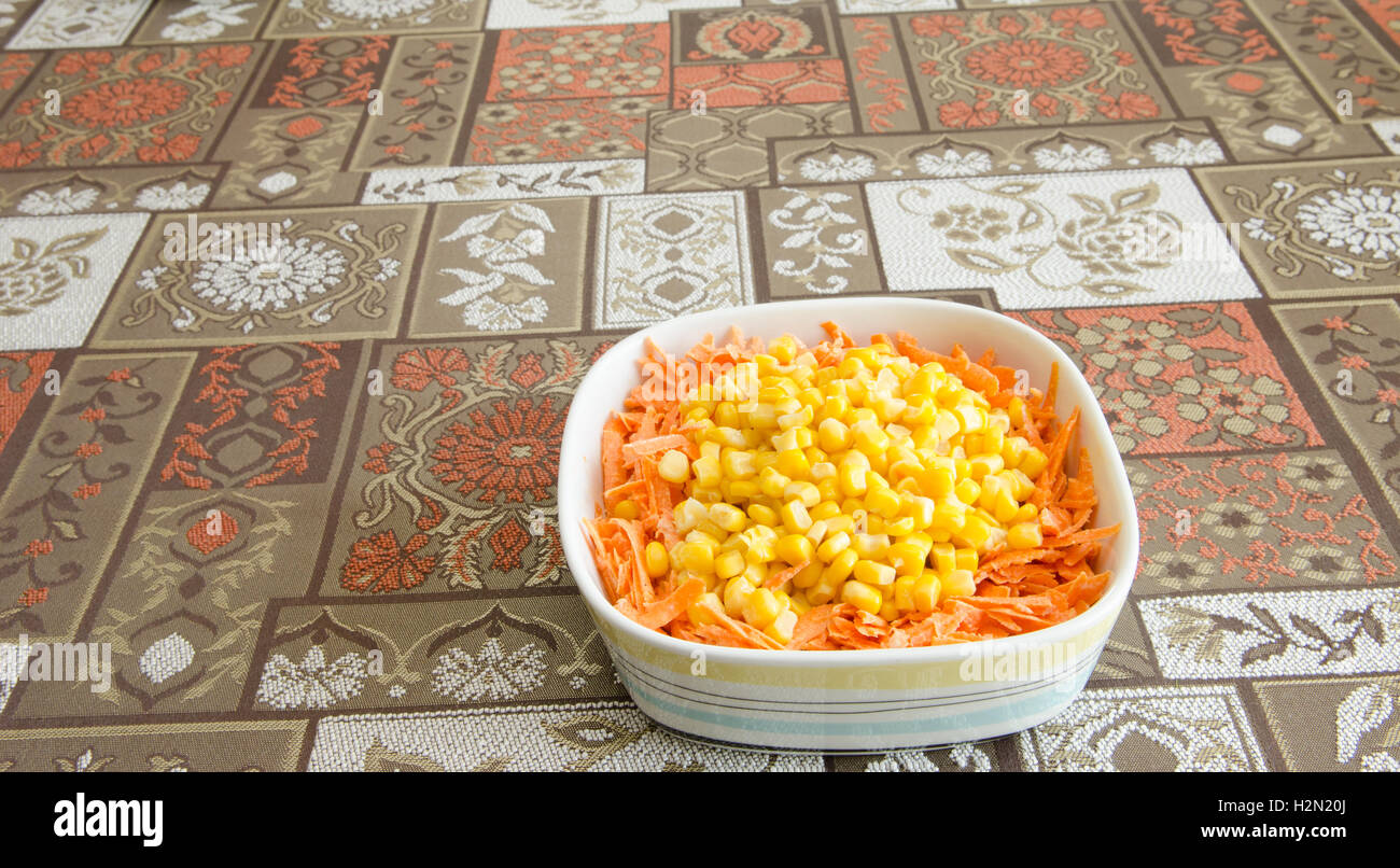 gestreifter Schale mit einem Salat mit Mais und Karotten Stockfoto