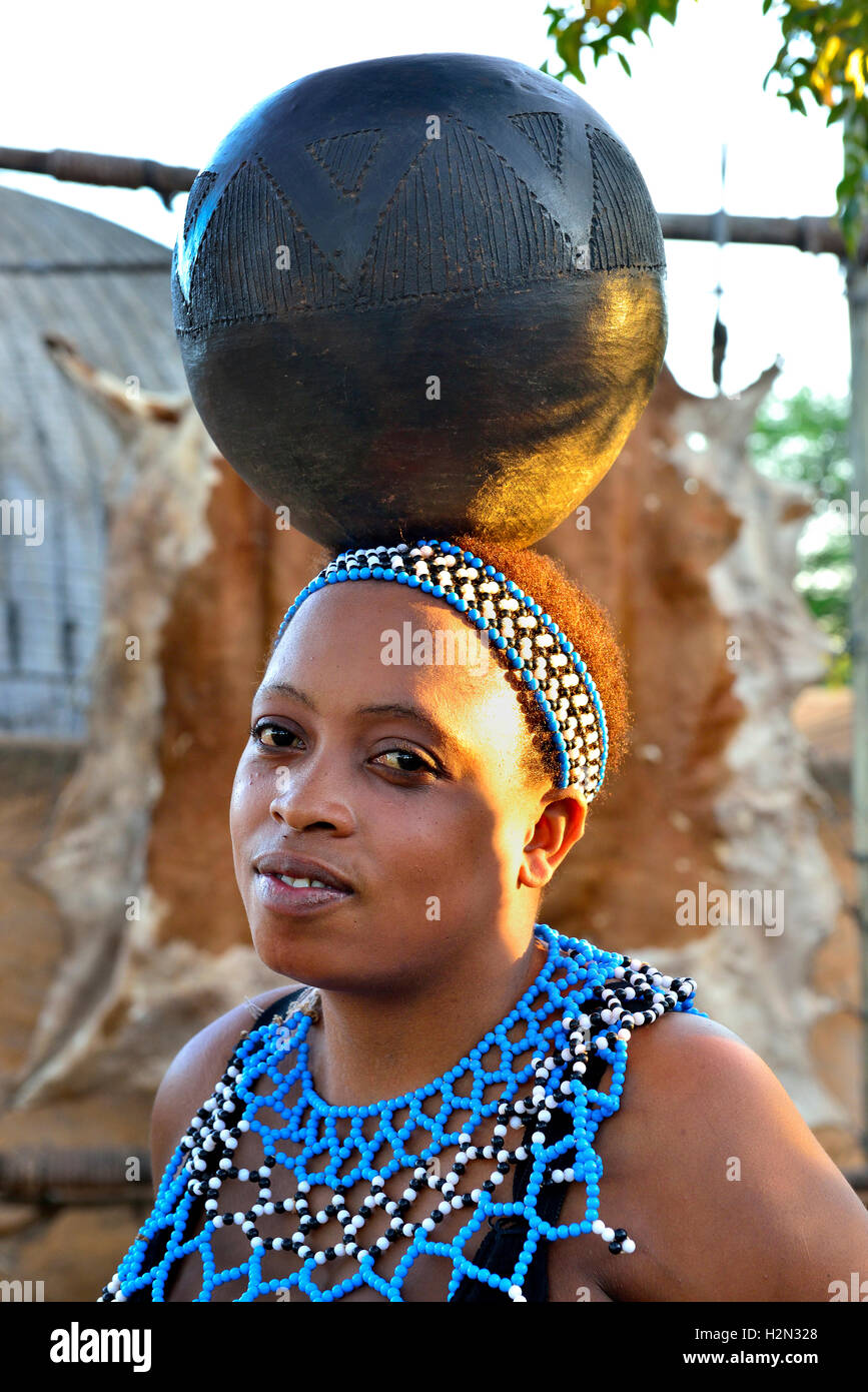 Zulu Mädchen Performer im Shakaland Cultural Village mit einem Wasser - Schüssel auf dem Kopf während eines Zulu Erfahrung, Leistung, Südafrika Stockfoto