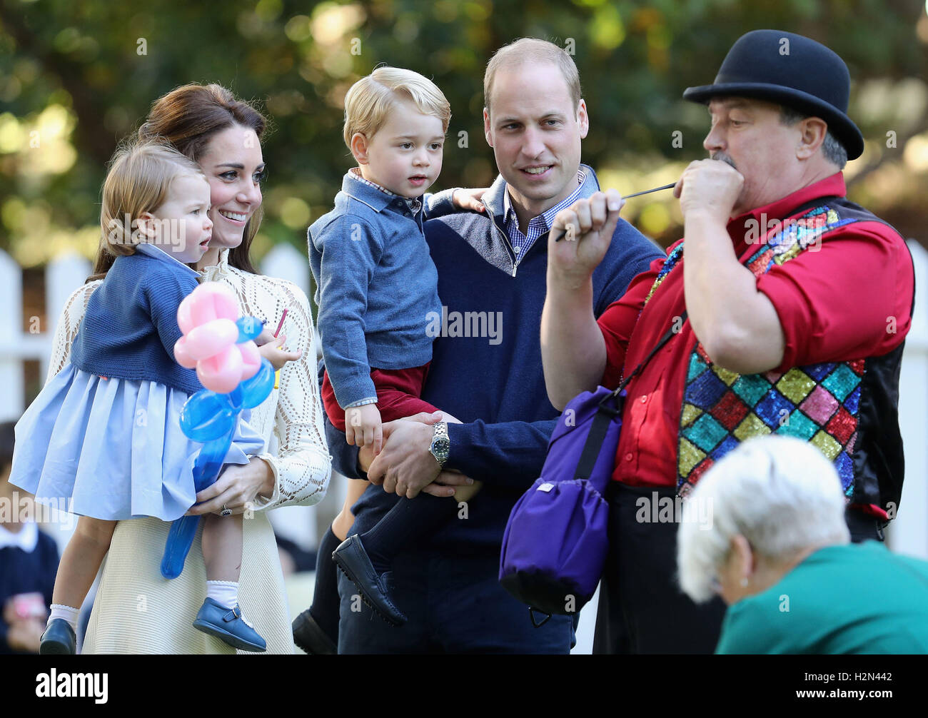 Die Herzogin von Cambridge hält Prinzessin Charlotte und Prinz Georg durch den Duke of Cambridge mit bei einer Kinder Party bei einem Kinderfest für Soldaten und deren Angehörige am Government House in Victoria während der Royal Tour of Canada statt. Stockfoto