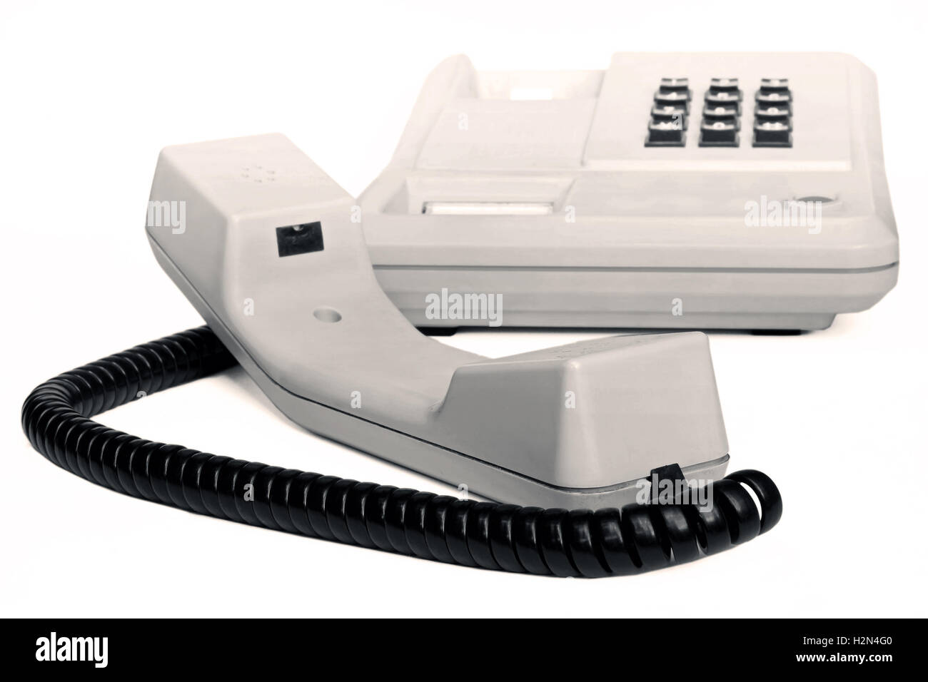 Alte einfache Büro-Tischtelefon in Sepia isoliert auf weißem Hintergrund Stockfoto