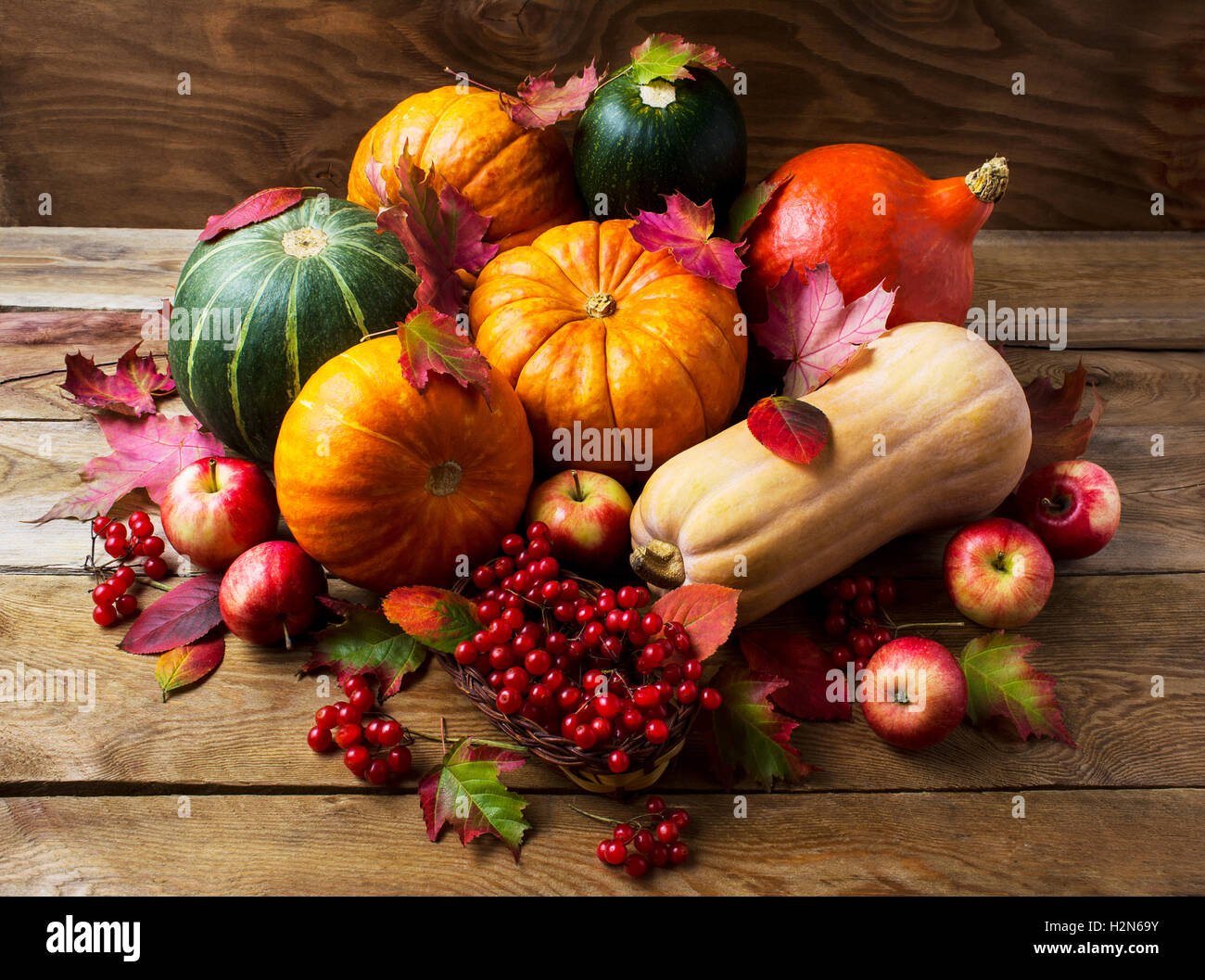 Reiche Ernte-Konzept mit Kürbissen, Äpfeln und Beeren. Thanksgiving-Hintergrund mit saisonalem Gemüse und Früchten. Herbst-ba Stockfoto