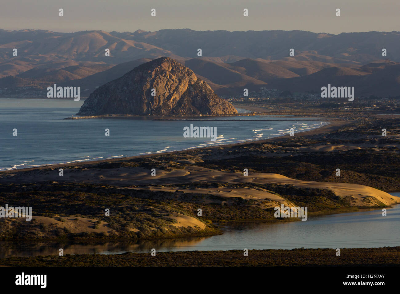 Sonnenaufgang über den Sanddünen und Morro Rock in Morro Bay, Kalifornien Stockfoto
