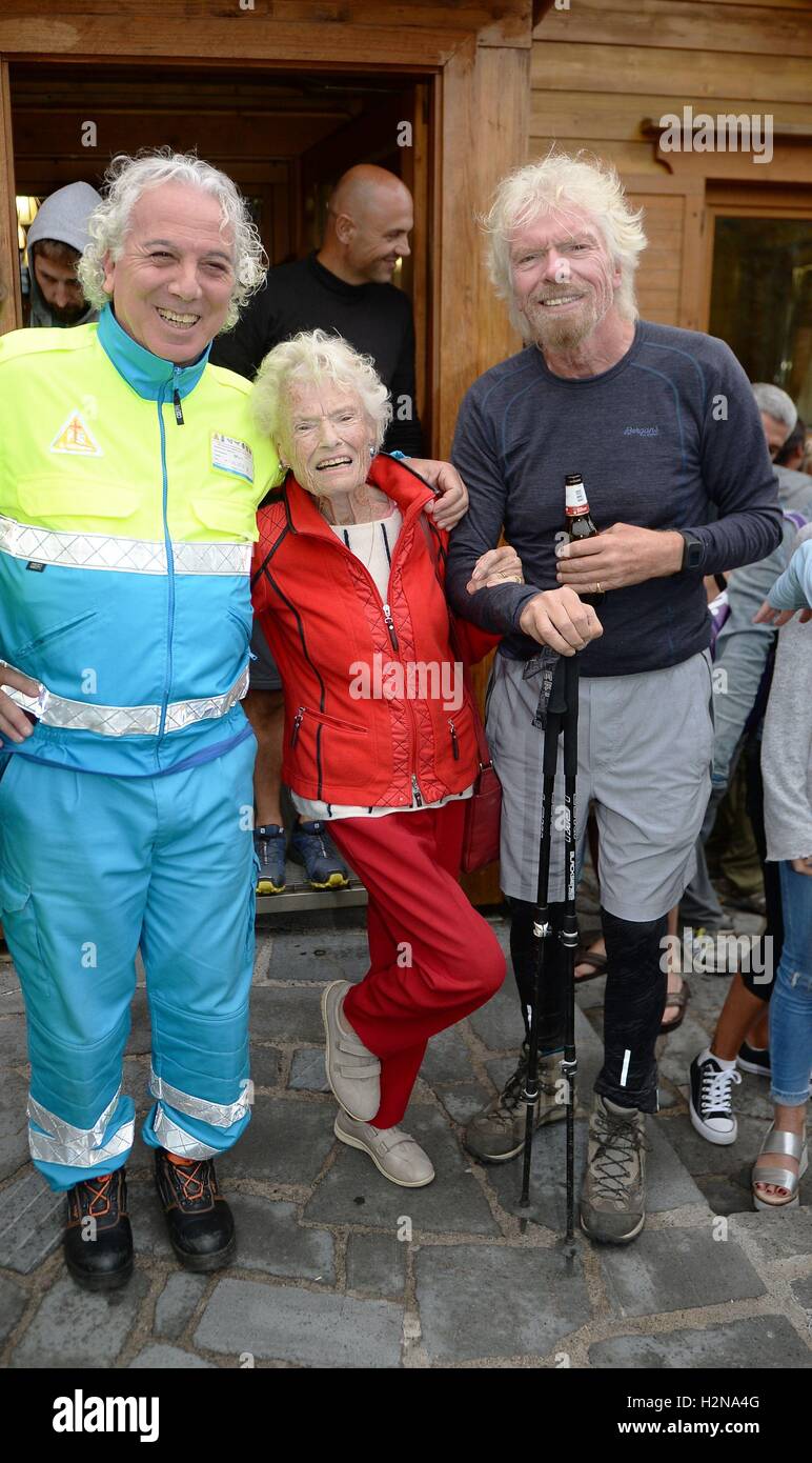 Sir Richard Branson mit seiner Mutter Eve und lokalen Sanitäter nach Abschluss der Jungfrau streben Challenge 2016, in denen Teilnehmer ausgeführt haben, ging und radelte für einen guten Zweck vom Matterhorn Berg in der Schweiz, alle durch die Länge von Italien auf der Insel Sizilien. Stockfoto