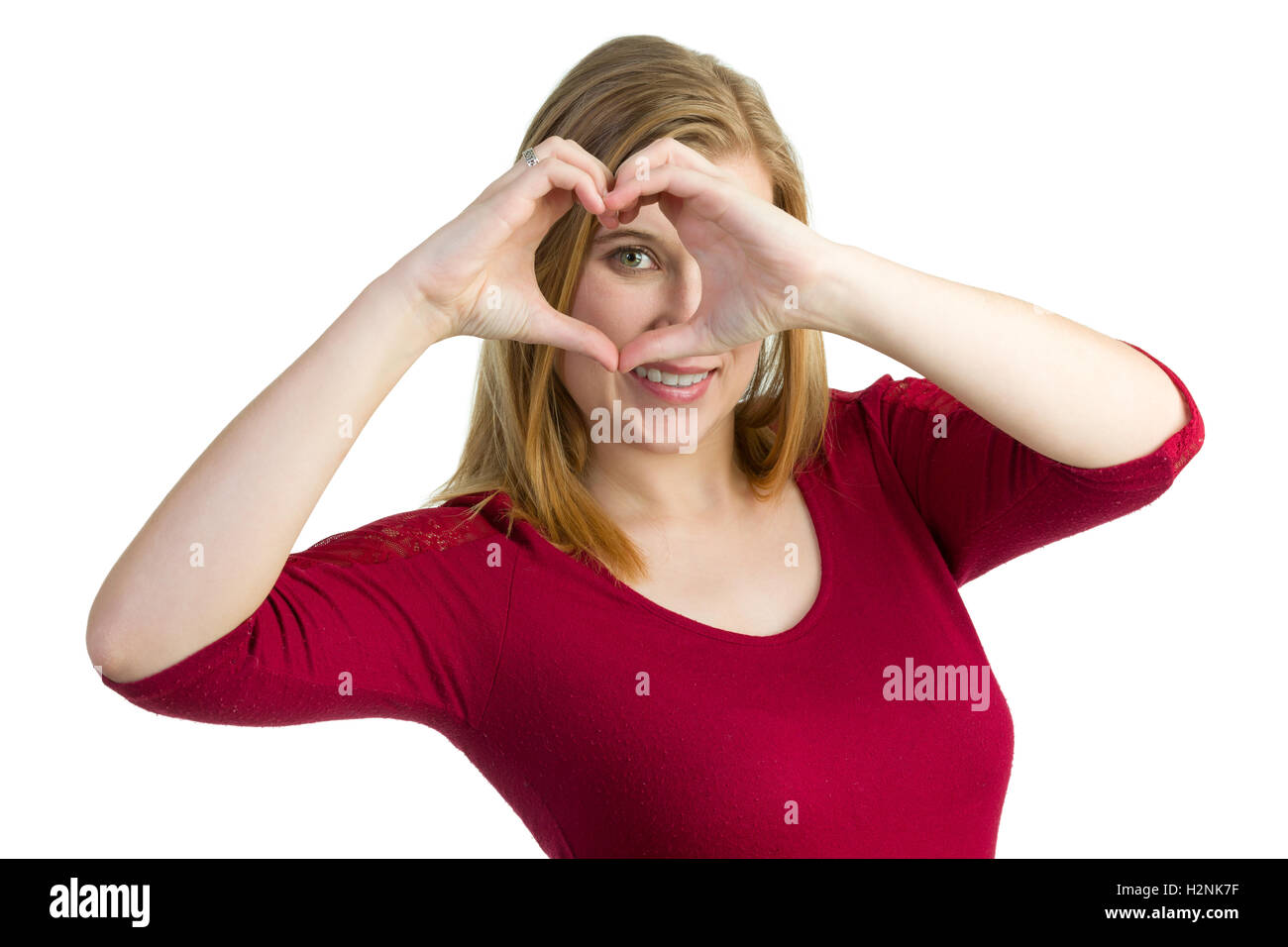 Attraktive blonde Frau ein Herzsymbol mit ihren Händen zu machen und uns über es. Stockfoto