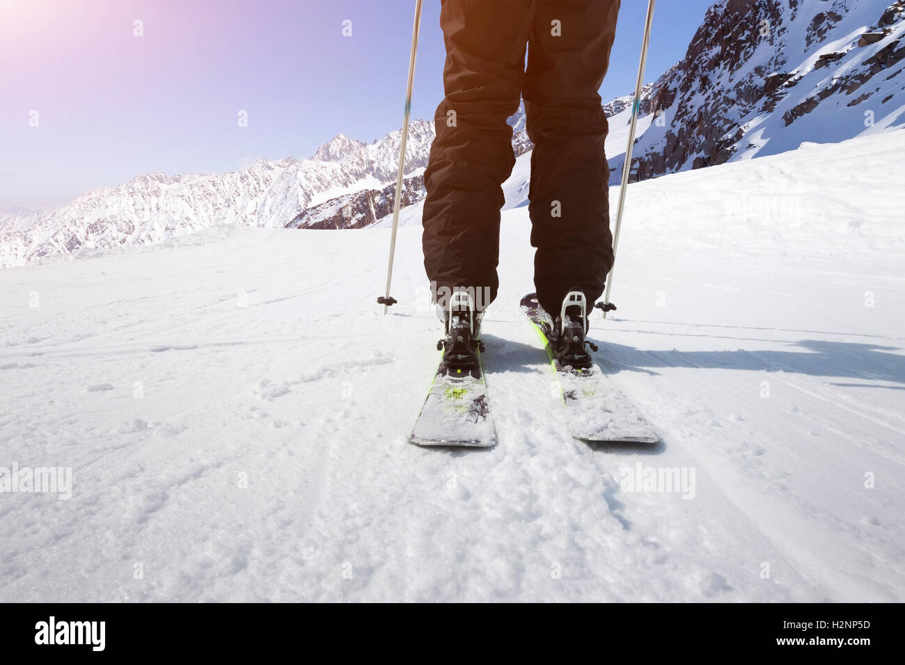 Nahaufnahme von der Rückseite eines Skifahrers mit einem Panorama der hohen Berge rund um Skifahren Stockfoto