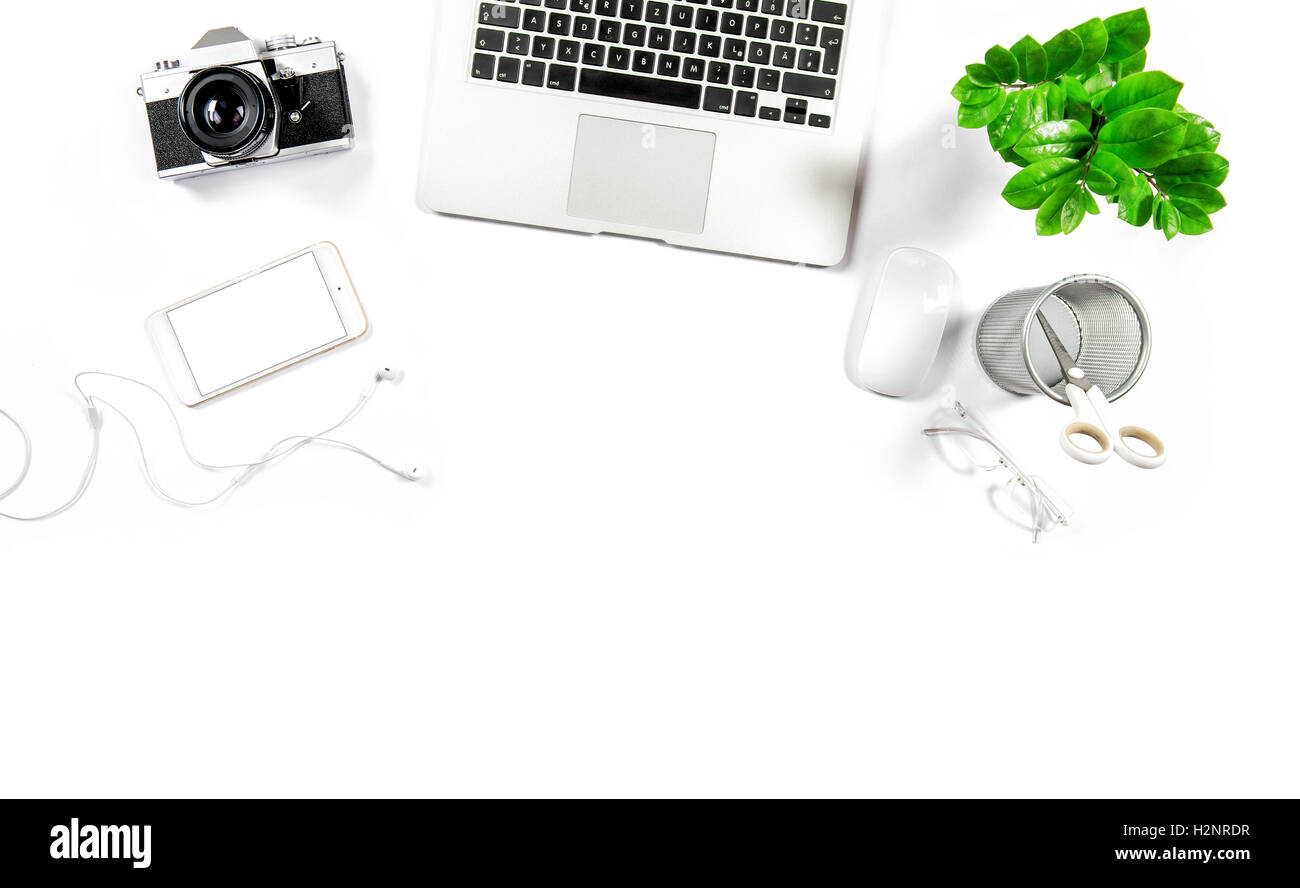 Schreibtisch mit Laptop, Handy, Notebook, Fotoapparat, grüne Pflanze. Flache Laien weißen Hintergrund Stockfoto