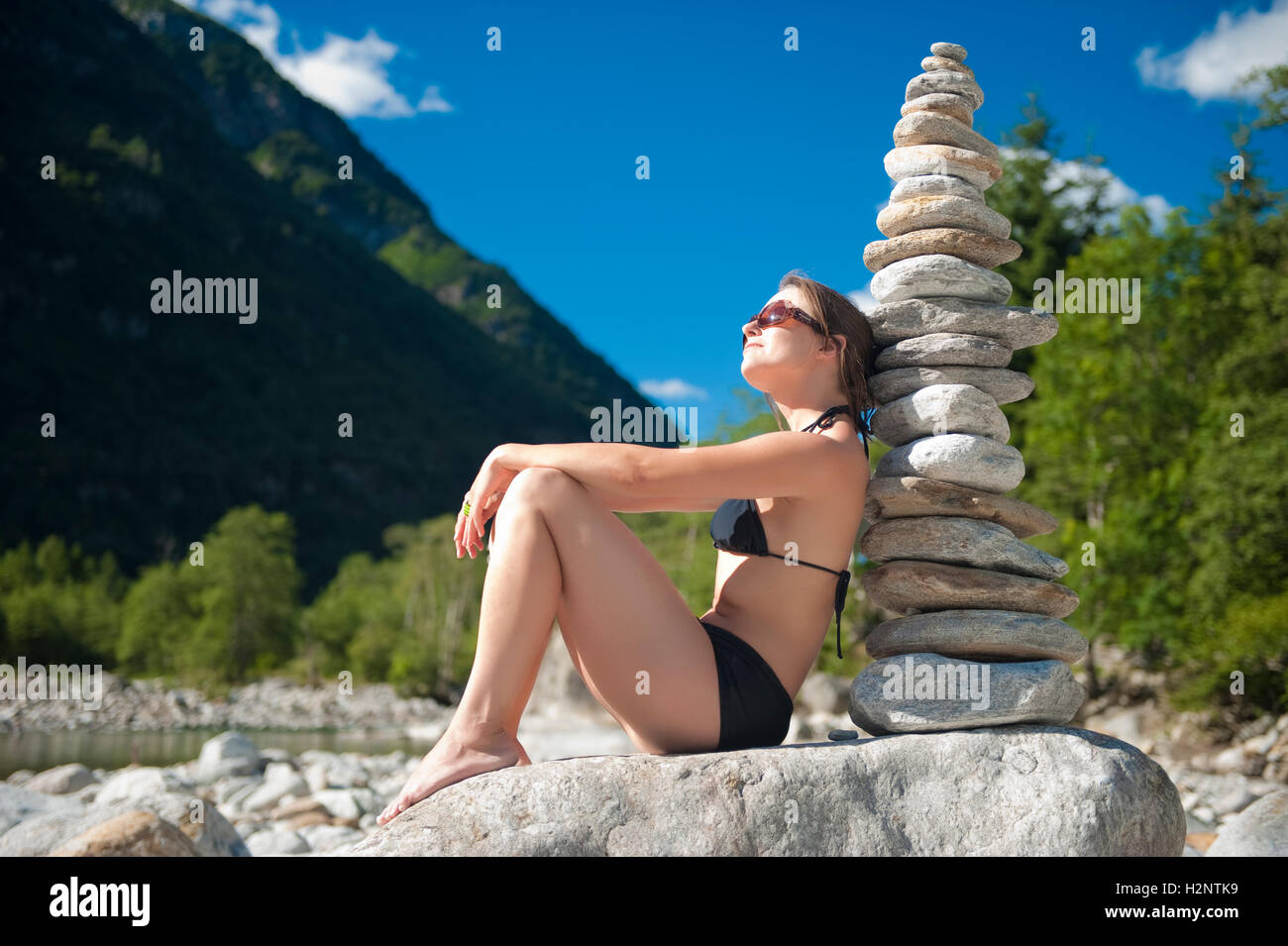 Frau im Bikini neben einer Steinpyramide, Valle Verzasca, Tessin, Schweiz, Europa Stockfoto