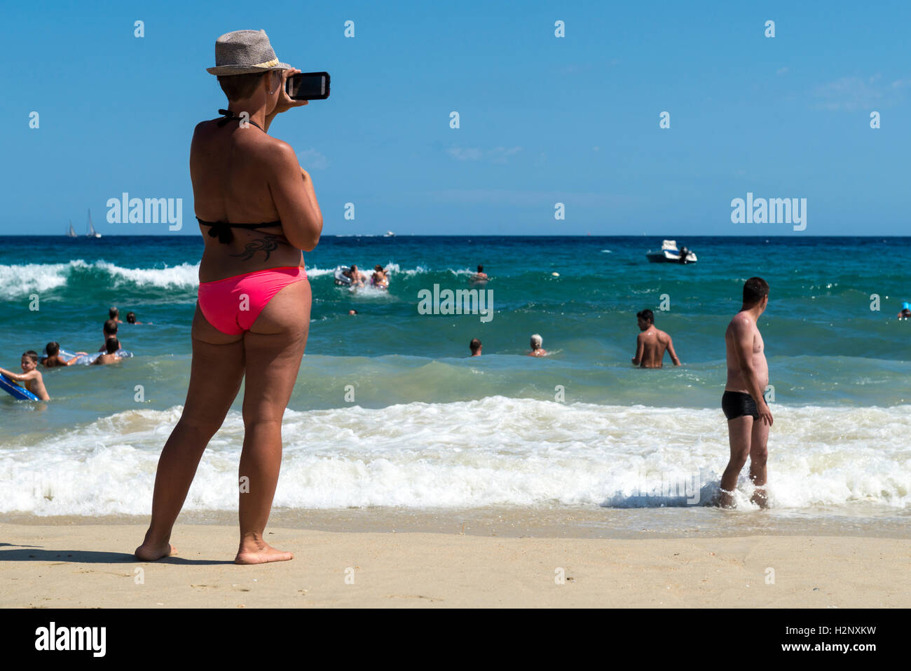 Frau, die ein Bild mit einem Smartphone auf der Region Strand Le Lavandou, Provence-Alpes-Côte d ' Azur, Frankreich Stockfoto