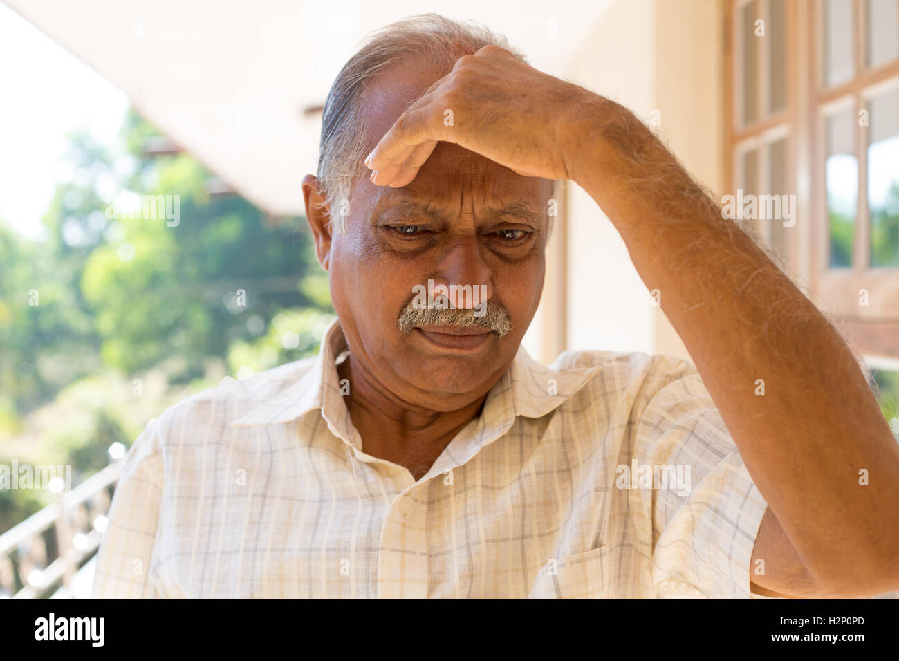 Closeup Portrait, mürrisch ältere Rentner, niedergeschlagen, düster, ruhenden Hand auf Kopf, draußen im Freien zu Hause Hintergrund isoliert Stockfoto