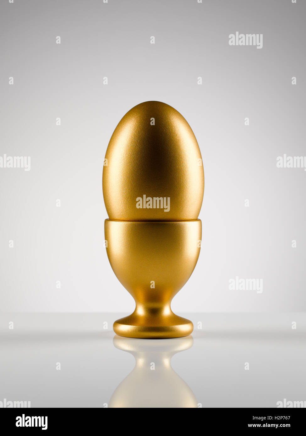 Goldenes Ei in Ei Becherhalter auf weißen Hintergrund Stockfoto
