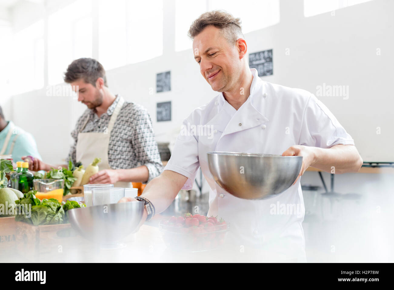 Koch Lehrer halten Schalen in der Küche Klasse Küche Stockfoto