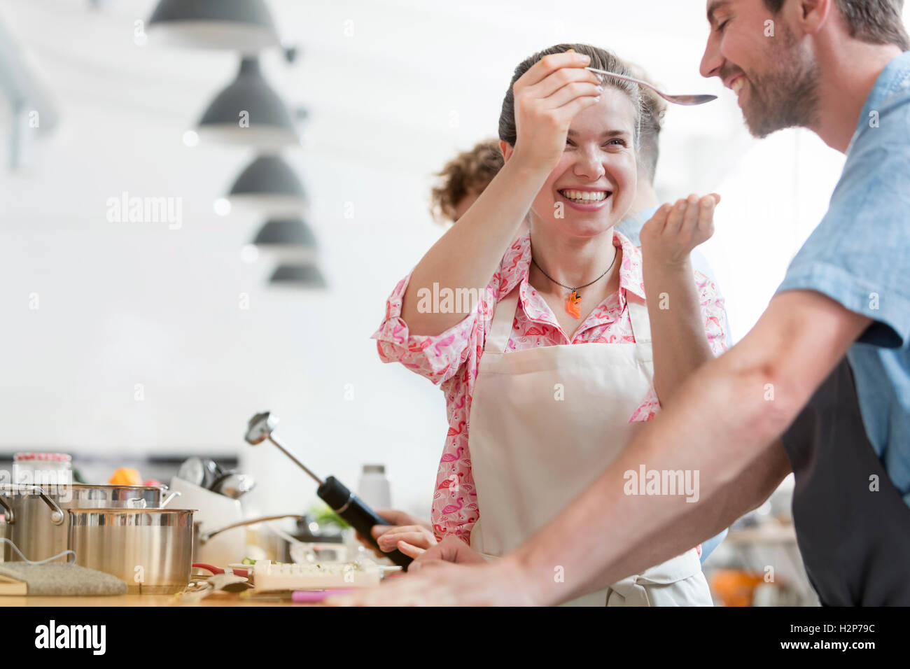 Lächelnde paar schmeckendes Essen in der Küche Klasse Küche Stockfoto