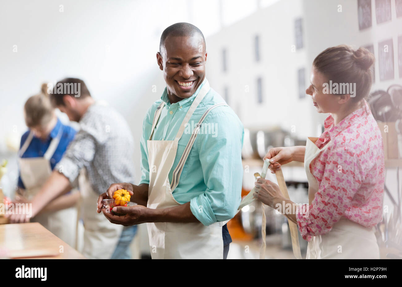 Lächelnde Frau binden Schürze für Mann in der Küche Klasse Küche Stockfoto