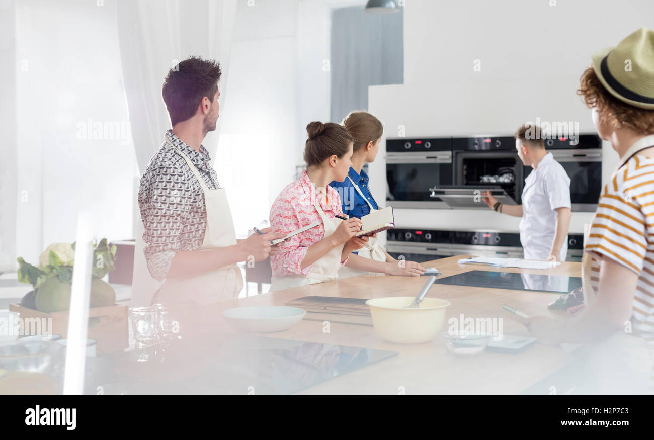 Studenten, Notizen und beobachtete Koch Lehrer am Ofen in der Küche Klasse Küche Stockfoto