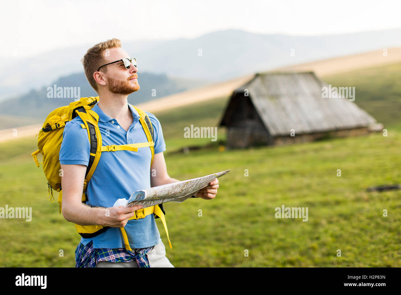 Junge Redhair Mann auf Bergwanderungen im Besitz einer Karte Stockfoto