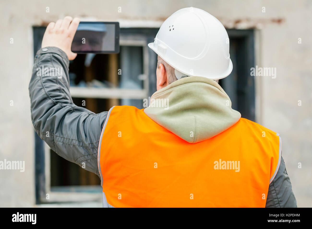 Bau-Inspektor mit Tablet-PC in der Nähe von Gebäude Stockfoto