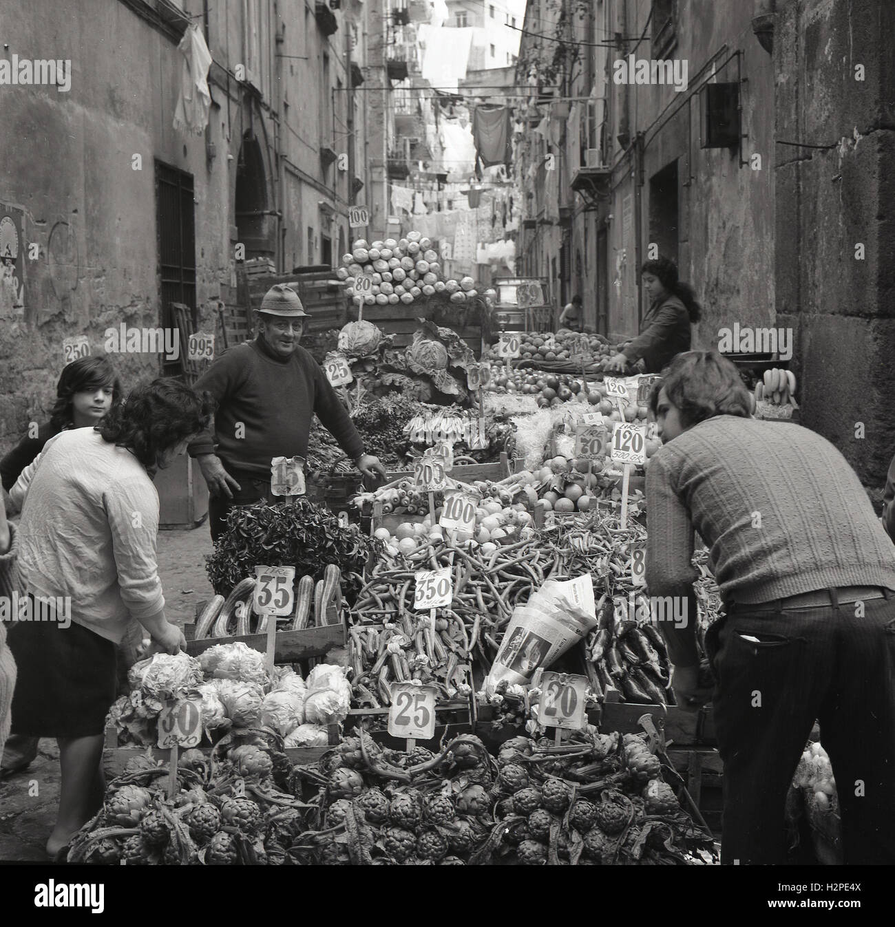 1950er-Jahren, historische, zeigt Bild die Besitzer und das Personal einer Straßenmarkt Stall Verkauf von Gemüse, mit Preisen in italienischen Lire, Sizilien, Italien. Stockfoto