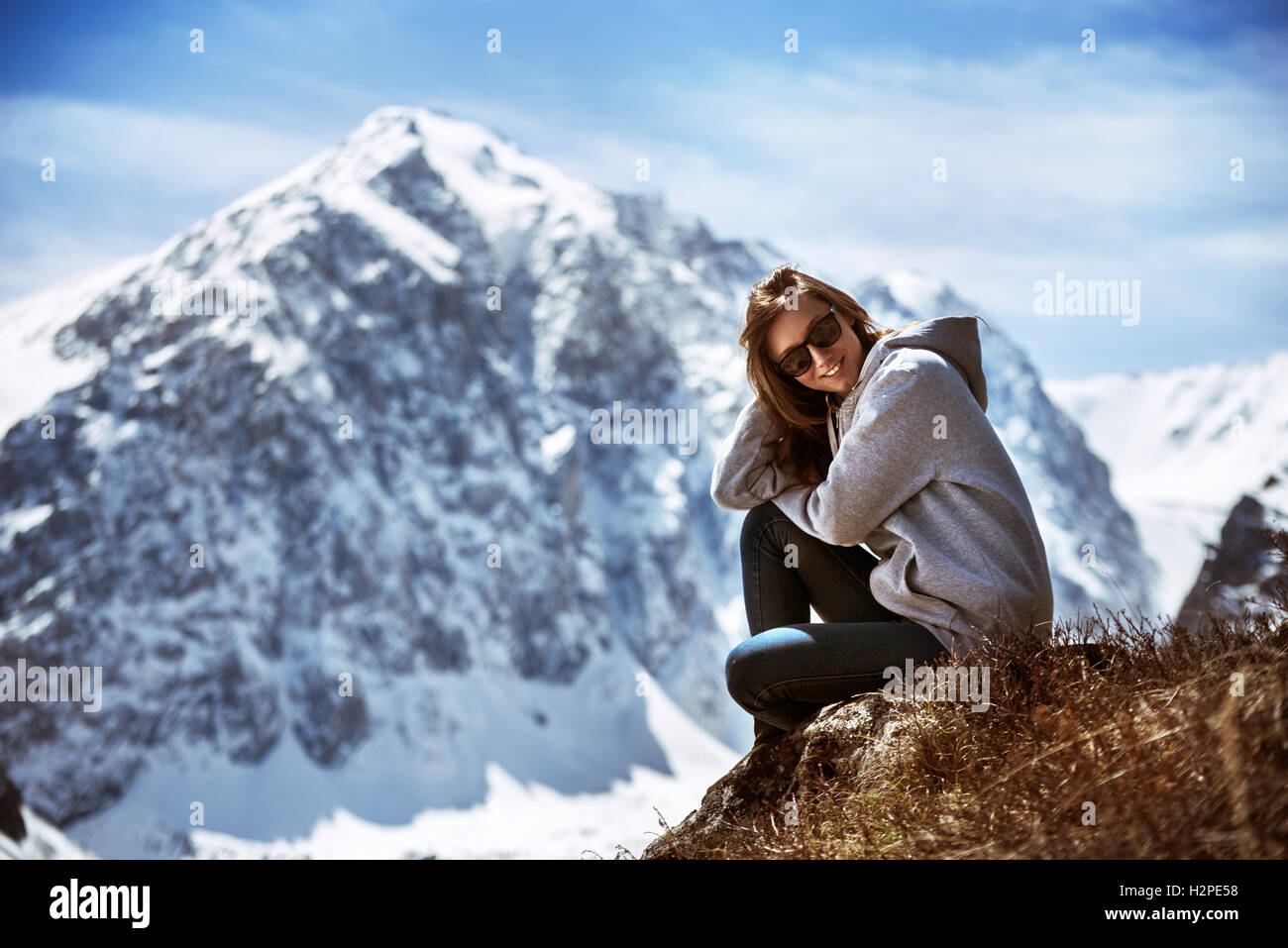 Schönes Mädchen sitzt auf Bergkulisse Stockfoto