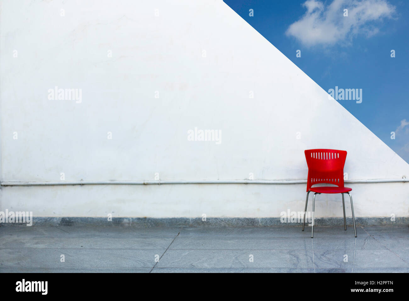 RAID-Stuhl gegen weiße Wand und blauer Himmel im Hintergrund Stockfoto