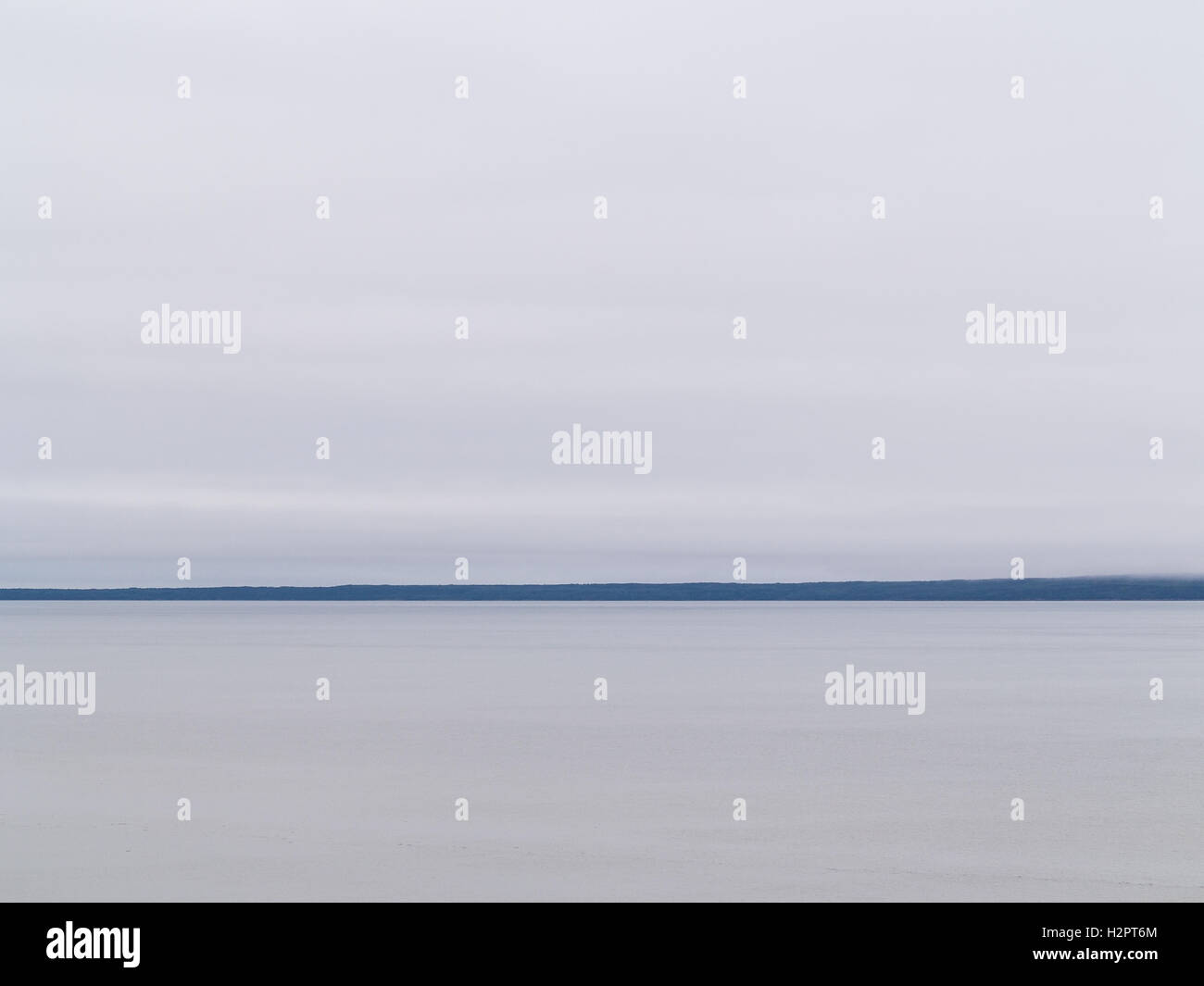 Minimalistische, launisch Blick auf einen fernen Landform, Himmel und Wasser mit einem Hauch von Nebel Stockfoto