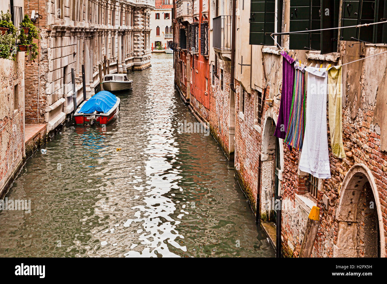 Alltag in Venedig entlang der kleinen peripheren Kanal mit alten Backsteinmauern der gealterte Gebäude Häuser, Fenster und Wäsche Stockfoto