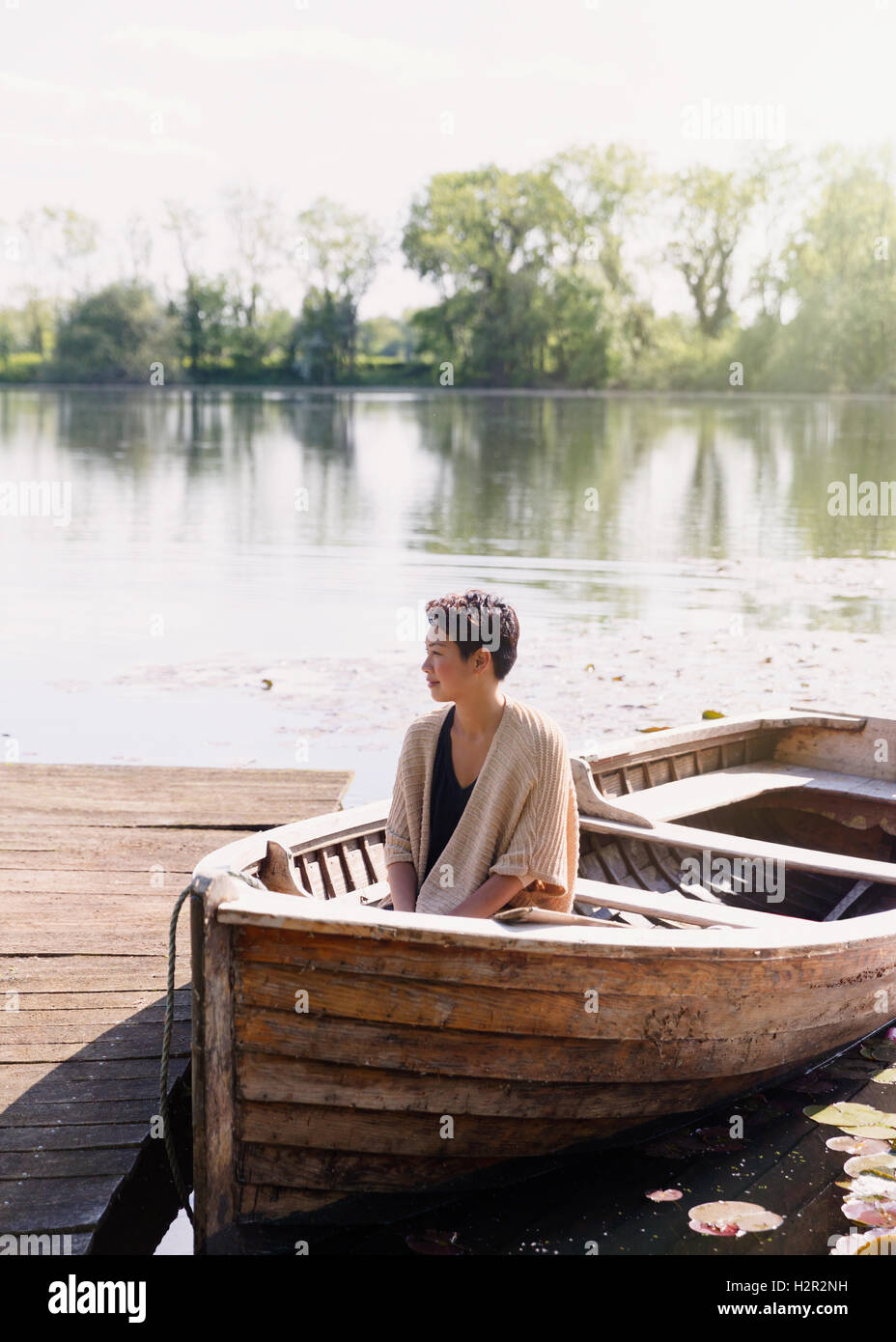 Dock-heitere Frau im Kanu am sonnigen Seeufer Stockfoto