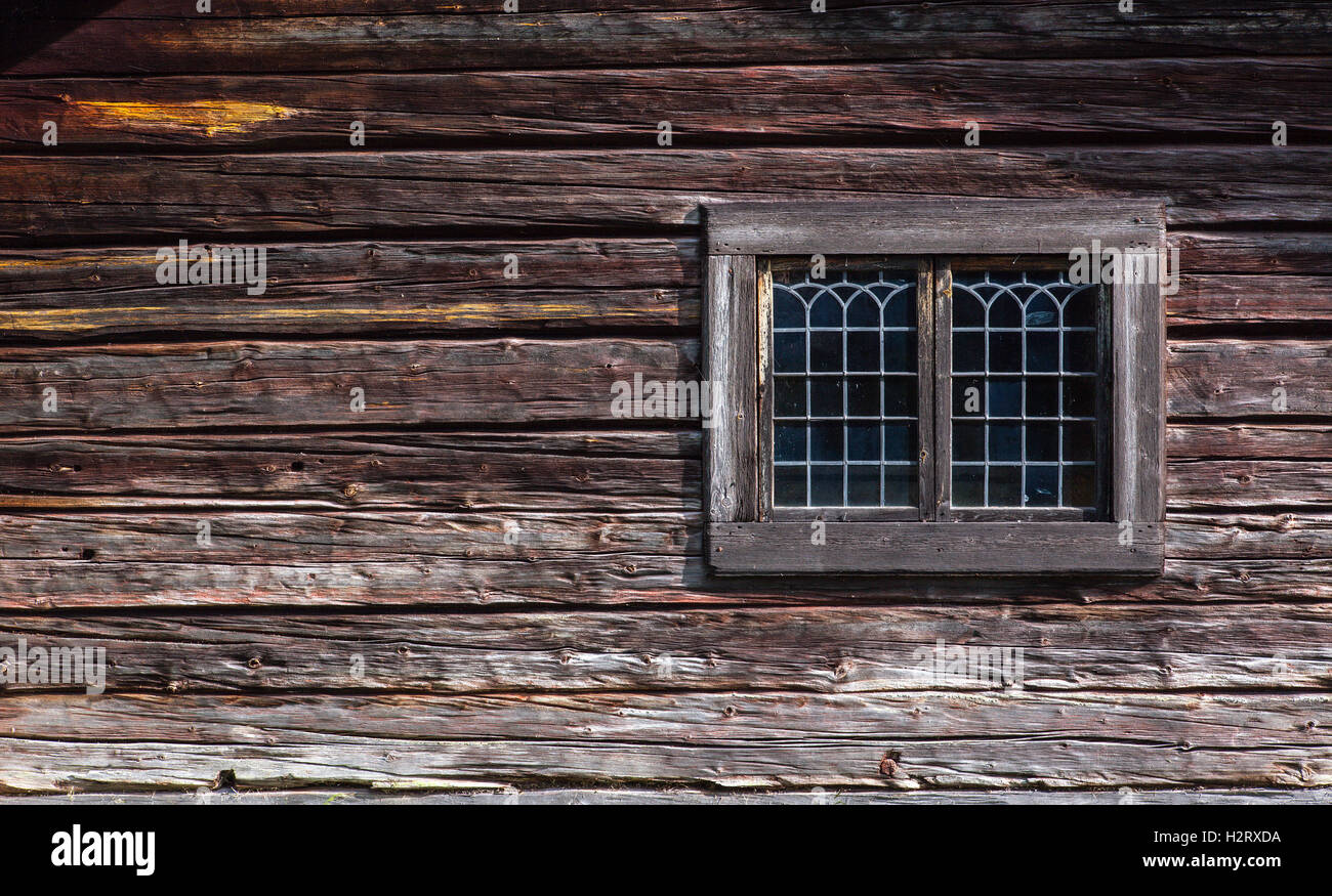 Elegante verglaste Fenster an einer Holzwand Holz. Leistungsstarke Holz, Blockkonstruktion in Nahaufnahme. Stockfoto