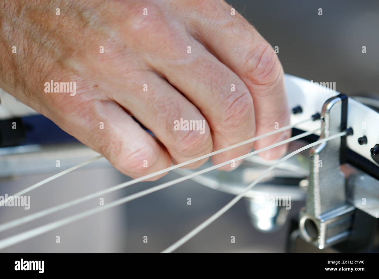 Ein älterer weißer Mann Bespannung Tennisschläger Stockfoto