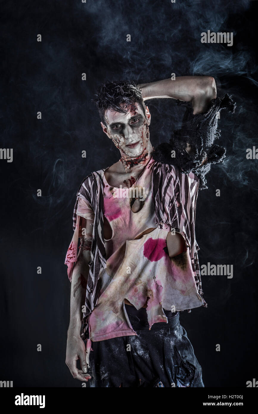 Männlichen Zombie stehen auf schwarzem Hintergrund, Blick in die Kamera. Halloween-Thema Stockfoto