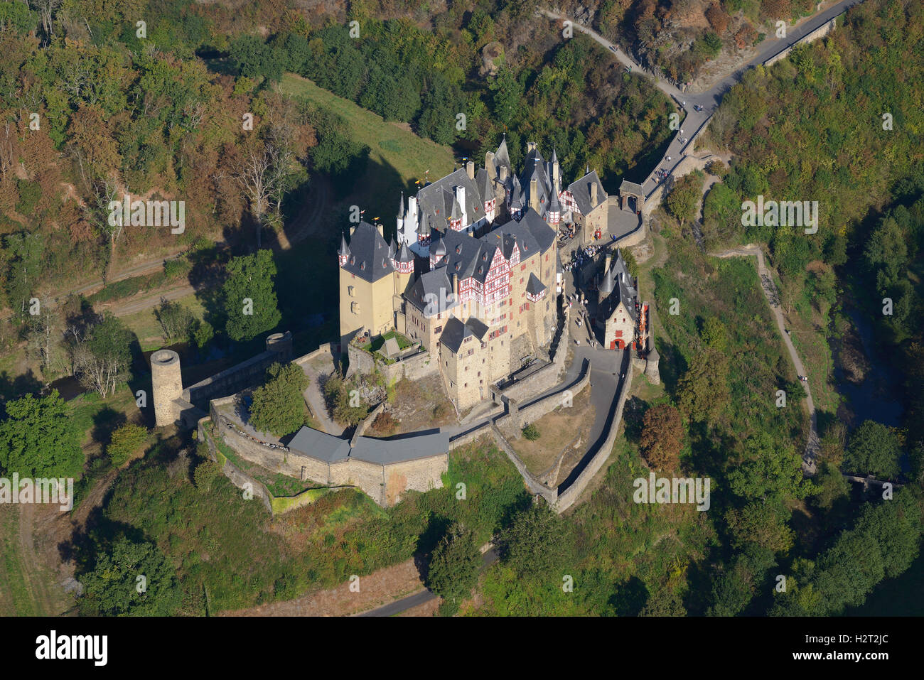 LUFTAUFNAHME. Mittelalterliche Burg in einer bewaldeten Umgebung. Schloss Elz, Wierschem, Rheinland-Pfalz, Deutschland. Stockfoto
