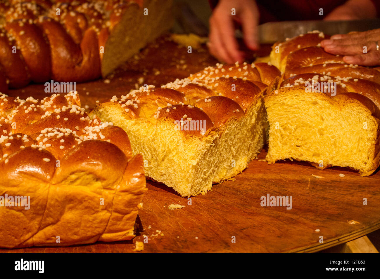 enorme Brioche-Brot wird bei Hochzeitsfeier in Frankreich in Scheiben geschnitten Stockfoto