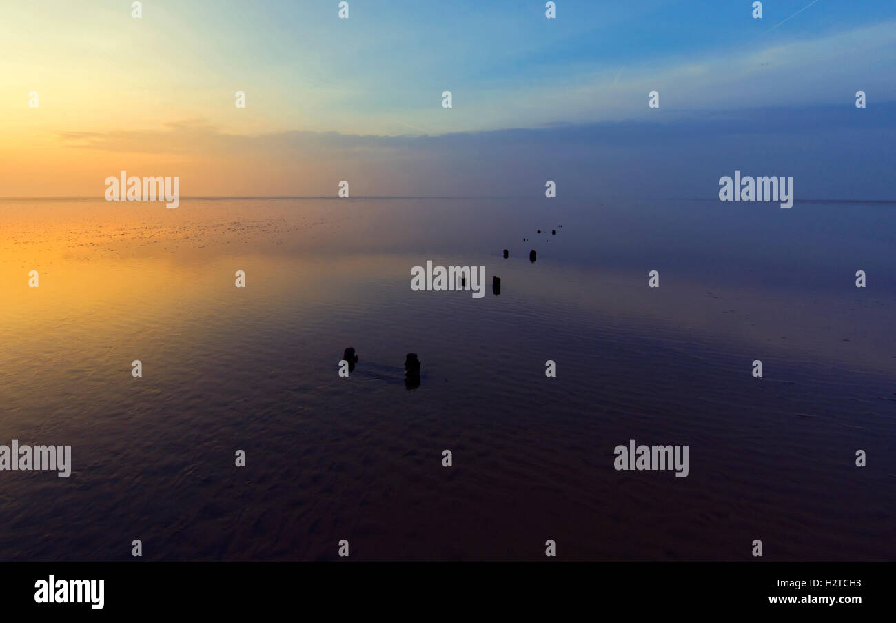 Sonnenuntergang spiegelt sich im nassen Sand der Morecambe Bay, Lancashire, UK Stockfoto