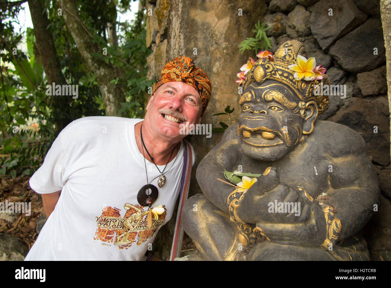 Indonesien, Bali, Tengannan, Bali Aga Dorf, touristische tragen Udeng Head Tuch und Hindu-Gottheit Schnitzerei Stockfoto